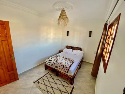 a bedroom with a bed with a leopard print sheets at Apparetemt essaouira welecom all in Essaouira