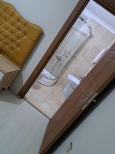 a bathroom with a toilet through a sliding glass door at AKUA 23 in Trabzon
