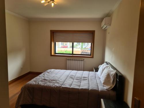 a bedroom with a bed and a window at Arcos de Valdevez, Recanto da Prova - PNPG in Arcos de Valdevez