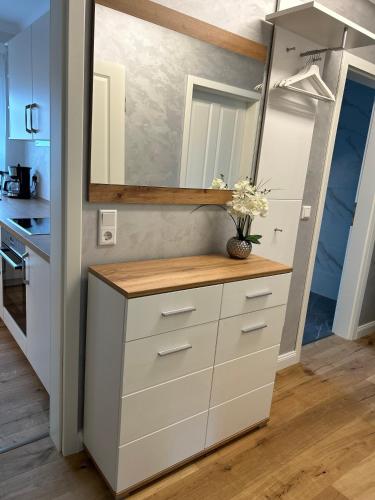 a kitchen with white cabinets and a mirror at FeWo by HD mit Parkplatz, Wallbox, Wintergarten in Bad Salzuflen