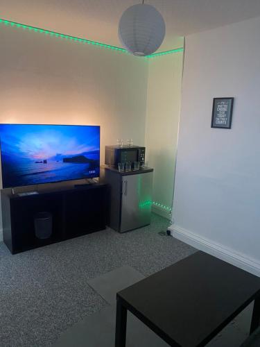 a living room with a flat screen tv on a wall at Sapphire Suites Stunning 2-Bed House in Bradford in Bradford