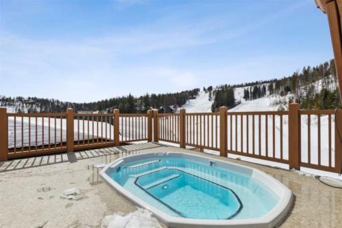 uma banheira de hidromassagem num pátio com uma cerca em Ski-in, Ski-out Whitefish Mountain Condo with Views and Pet Friendly em Whitefish