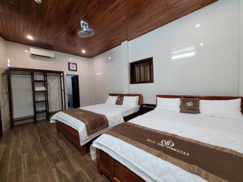 a bedroom with two beds and a wooden ceiling at Ngọc Anh homestay in Thôn Kim Long (1)