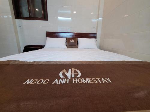 a hotel room with a bed with a mooc amh homestation sign on at Ngọc Anh homestay in Thôn Kim Long (1)