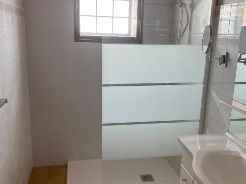 ein weißes Bad mit einer Dusche und einem Waschbecken in der Unterkunft Maison La Tranche-sur-Mer, 2 pièces, 2 personnes - FR-1-22-218 in La Tranche-sur-Mer