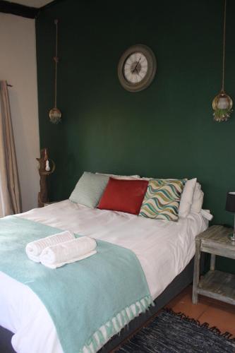 a bedroom with a bed with a clock on the wall at Patogeng Self Catering - Da Gama Dam view in White River