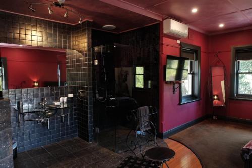 baño con paredes rojas y ducha de cristal en Oakdene Vineyards Guesthouse, en Wallington
