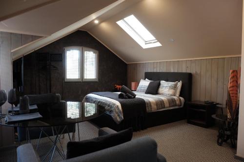 1 dormitorio con cama, mesa y TV en Oakdene Vineyards Guesthouse, en Wallington