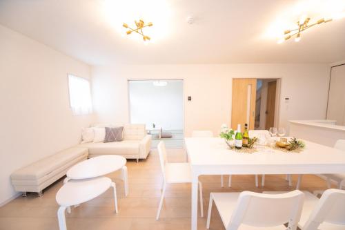 a white living room with a white table and chairs at Nagashima Riverside Resort 2 in Hakuro