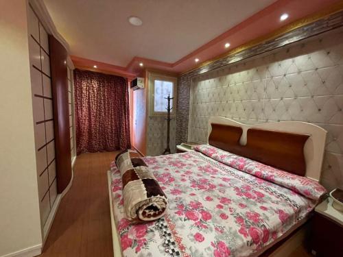um quarto com uma cama grande e um cobertor floral em شقة الجزيرة المميز كود 12-341 em Alexandria