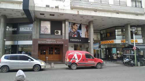 una camioneta roja estacionada frente a un edificio en Departamento Plaza, en Bahía Blanca
