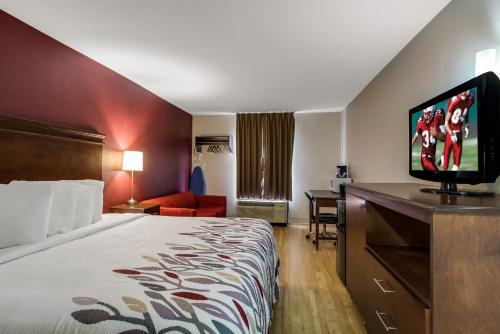 a hotel room with a bed and a flat screen tv at Red Roof Inn Nashville - Music City in Nashville