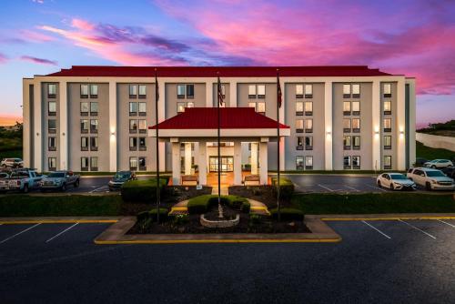a large white building with a red roof in a parking lot at Red Roof Inn Nashville - Music City in Nashville