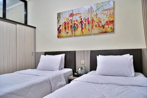 Umah Karet Homestay في ماغيلانغْ: سريرين في غرفة الفندق مع لوحة على الحائط