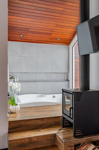 a bathroom with a bath tub and a television at Refúgio Galli in Encantado