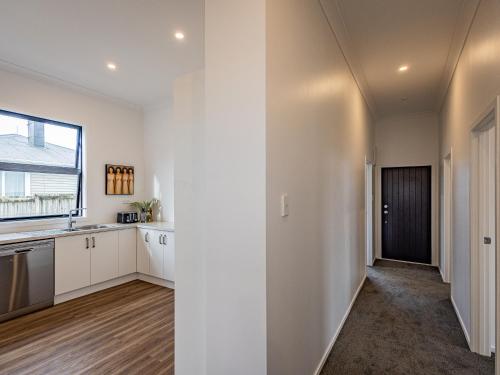 an empty kitchen with white cabinets and a window at Rata Retreat - Ohakune Holiday Home in Ohakune