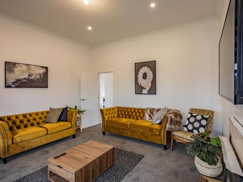a living room with two couches and a coffee table at Rata Retreat - Ohakune Holiday Home in Ohakune
