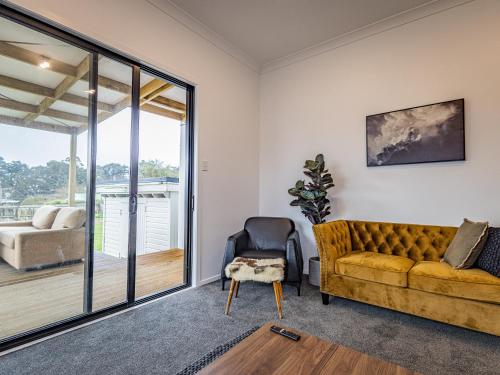 a living room with a couch and a chair at Rata Retreat - Ohakune Holiday Home in Ohakune