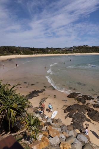 a beach with people swimming in the water at Reflections Scotts Head - Holiday Park in Scotts Head