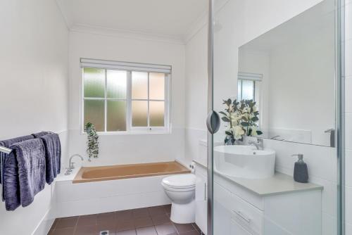 een badkamer met een bad, een toilet en een wastafel bij Hahndorf Creek Retreat - Unit 2 in Hahndorf