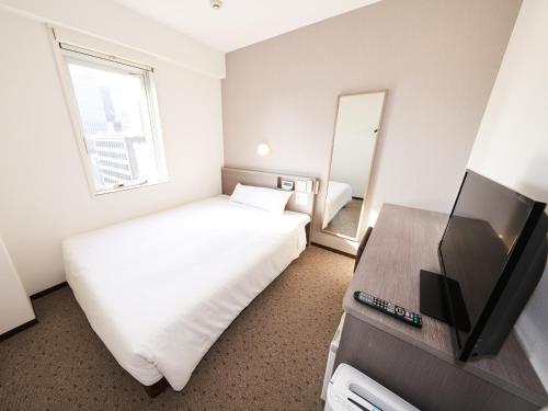 a hotel room with a bed and a television at Super Hotel Tokyo Nihombashi Mitsukoshimae in Tokyo