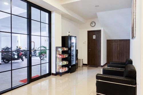 um salão com duas cadeiras e um relógio na parede em Urbanview Hotel Max Living Cengkareng em Jacarta