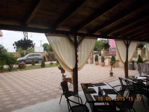 a patio with tables and chairs on a patio at Pensiunea Lari in Baile Unu Mai