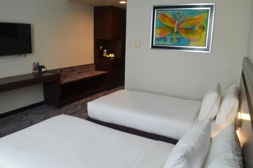 a hotel room with two beds and a television at Premiere Hotel - Complimentary Shuttle to Klang Wholesale Market in Klang