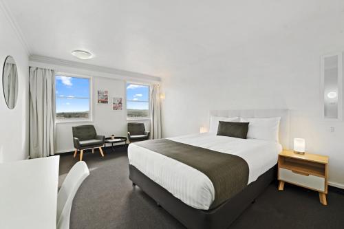 Habitación de hotel con cama, escritorio y sillas en Coach House Launceston en Launceston