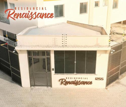 a white building with a sign on the front of it at Residencial renaissance in Boa Vista