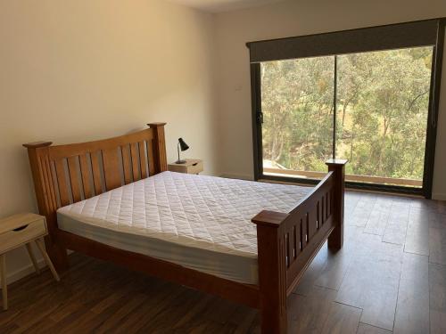 a bedroom with a bed and a large window at Taylor Bay Country Club in Eildon
