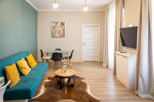a living room with a blue couch and a table at IZZY'S HIDDEN APARTMENT in Braşov