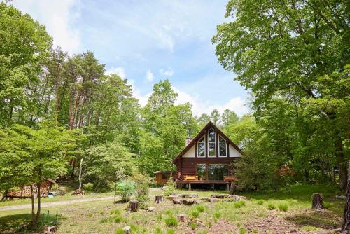a small cabin in the woods with trees at Yatsugatake HACHI - 八ヶ岳 ハチ - in Hokuto