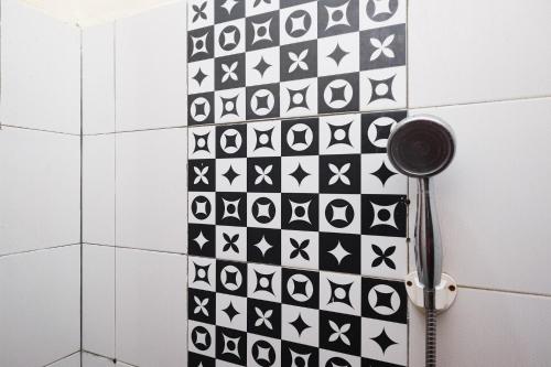 La salle de bains est revêtue de carrelage noir et blanc. dans l'établissement RedDoorz Syariah near Akmil Magelang, à Magelang