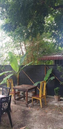 a wooden table and two chairs and a wooden table and chairs at Bunga Hostel Female Dorm in Pantai Cenang