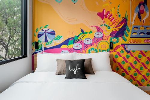 a room with a bed with a colorful wall at lyf Chinatown Kuala Lumpur in Kuala Lumpur