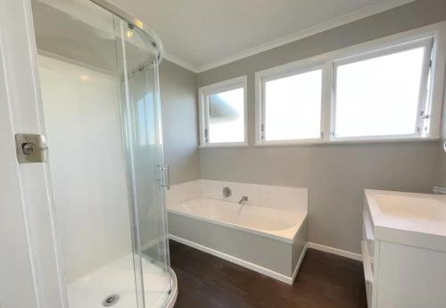 y baño con ducha, bañera y lavamanos. en 3 Bedroom family House in excellent Location, en Hamilton