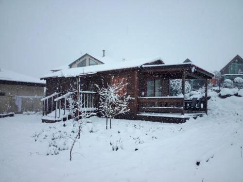 a house covered in snow in a yard at Orr Halevana in Bruchim Qela' Alon