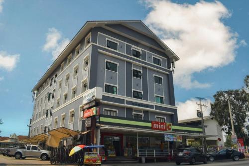 a tall gray building on the corner of a street at Chonlapruk Lakeside Hotel in Ban Si Than