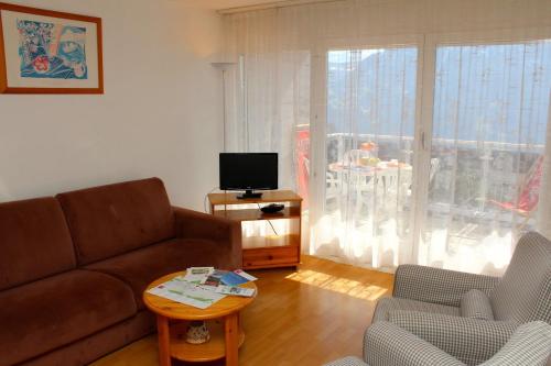 a living room with a couch and a television at Résidences du Chamossaire in Leysin