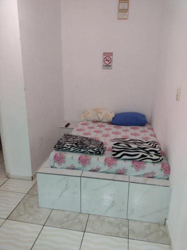 a small bedroom with a bed in a room at Hospedagem A Vale Verde in Londrina