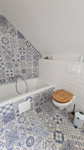 ein Badezimmer mit einer Badewanne und einem WC mit einem Holzsitz in der Unterkunft Kurešček in Ig