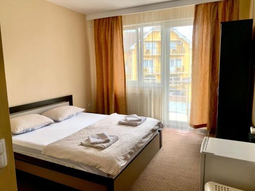 a bedroom with a bed with two towels on it at Pensiunea ALAS in Baile Felix