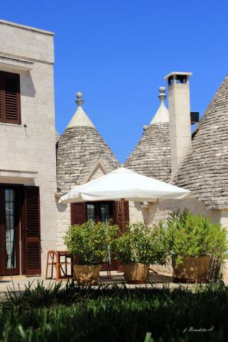 a white umbrella sitting in front of a building at Masseria Peppeturro in Cisternino