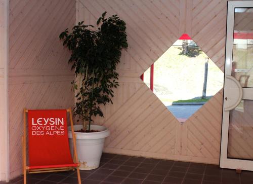 a house with a plant in a room with a sign at Résidences du Chamossaire in Leysin