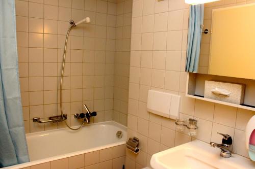 a bathroom with a shower and a tub and a sink at Résidences du Chamossaire in Leysin