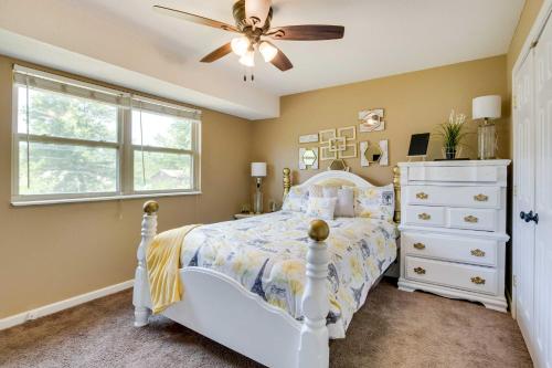 1 dormitorio con cama blanca y ventilador de techo en Cozy Missouri Retreat with Deck and Grill, Near Hiking en Lees Summit
