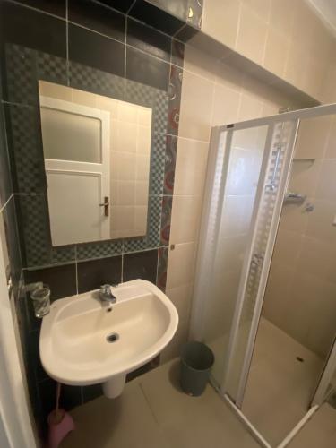 ein Bad mit einem Waschbecken, einer Dusche und einem Spiegel in der Unterkunft Chalet Marina Alamein first row sea view 3 bedroom-North Coast in El-Alamein