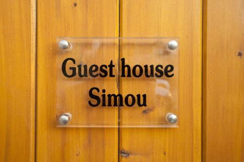 a sign on a door with the words guest house simotomy at Guesthouse Simou with view 3 bedrooms in Arachova