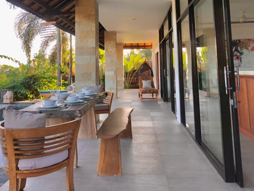 a dining room with a table and chairs on a patio at Maya Villa in Candidasa